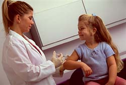 Женщина делает прививку маленькой девочке